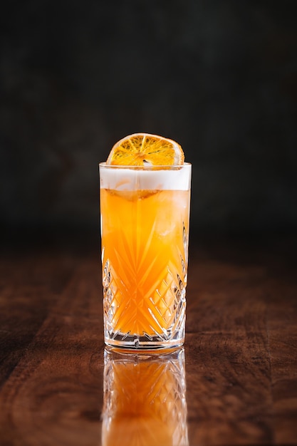 Sour cocktail on the wooden table with reflection