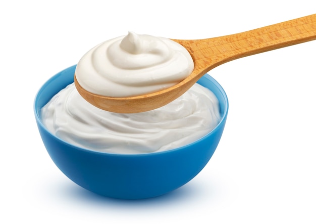 Panna acida in ciotola e yogurt greco su cucchiaio di legno isolato su sfondo bianco