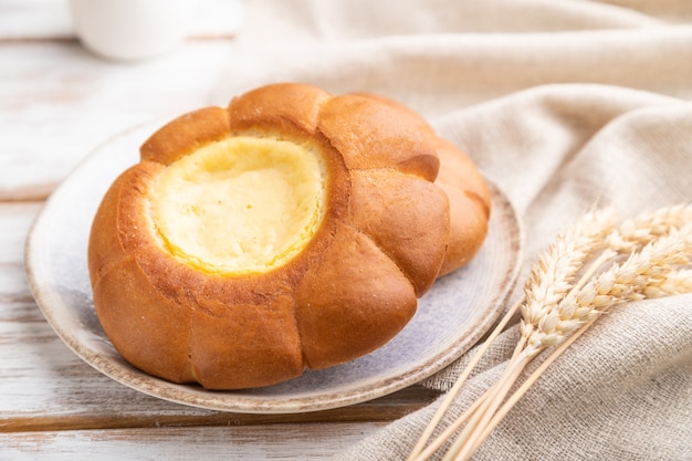 Sour cream bun with cup of coffee   and linen textile.