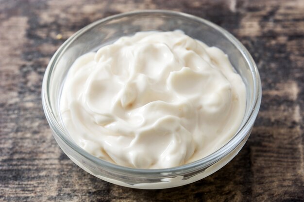 Photo sour cream in crystal bowl on wooden table