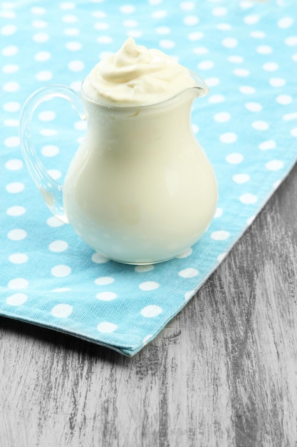 Sour cream in pitcher on table closeup