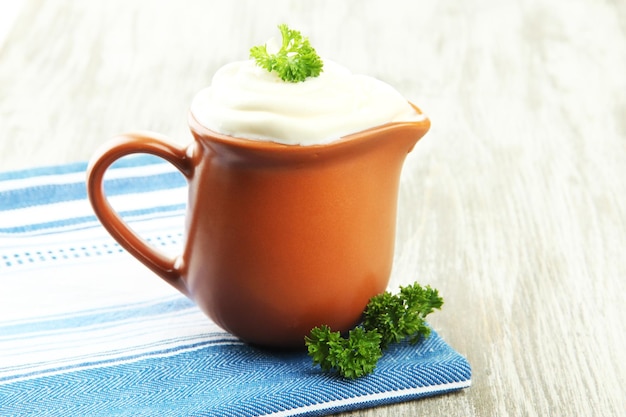 Sour cream in pitcher on table closeup