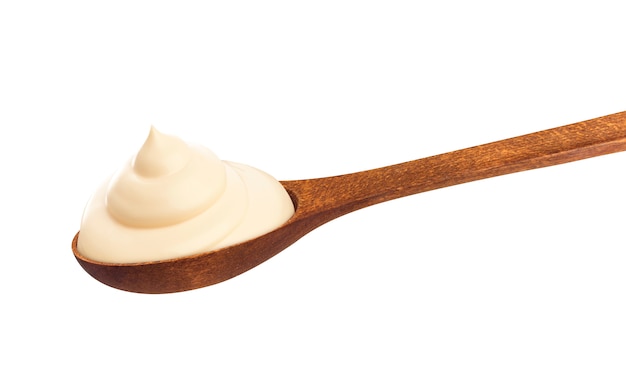 Sour cream in wooden spoon isolated 