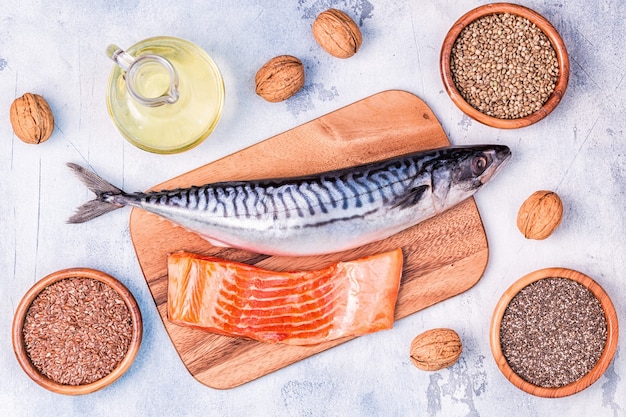 Fonti di omega 3: sgombro, salmone, semi di lino, semi di canapa, chia, noci, olio di semi di lino. concetto di mangiare sano. vista dall'alto con copia spazio.