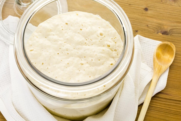 Sourdough starter in large glass jar on the table.