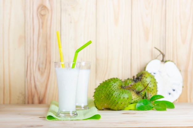 Soursop juice with soursop fruit on wooden table.