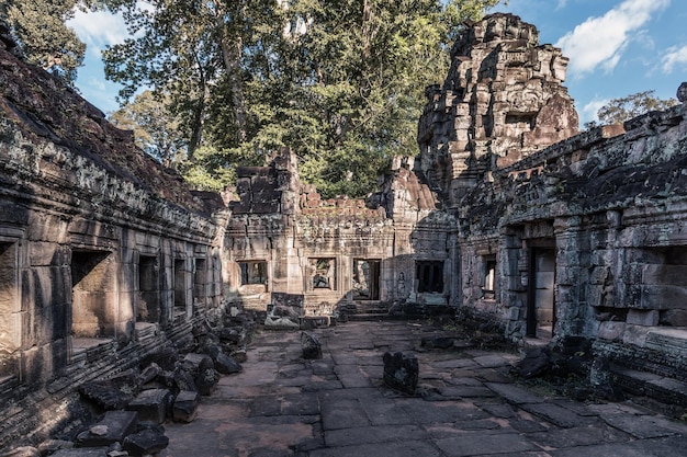 Sourtyard of ancient Cambodian temple among trees in Angkor complex Siem Reap Cambodia