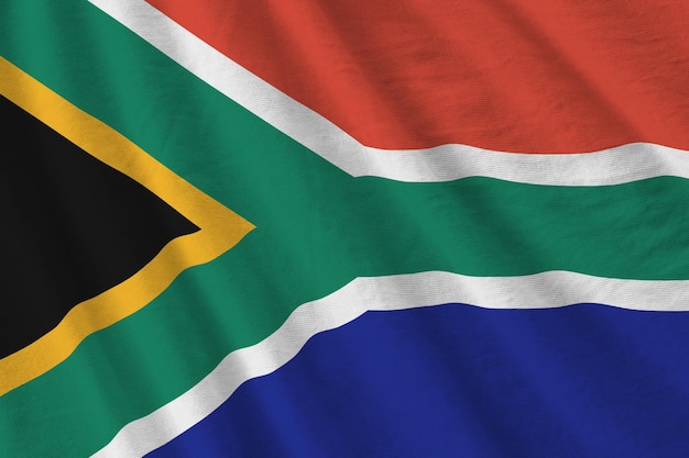 Photo south africa flag with big folds waving close up under the studio light indoors the official symbols and colors in banner