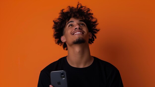 Photo south african coloured black shirt on phone looking into the future orange gradient background