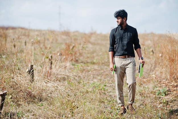 Южноазиатский фермер-агроном с буфером обмена осматривает срезанные деревья в фермерском саду Концепция сельскохозяйственного производства
