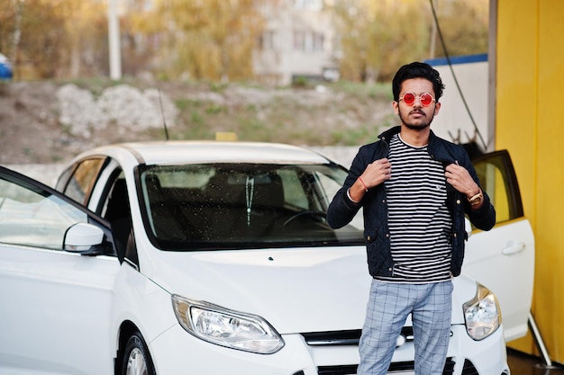 Photo south asian man or indian male washing his white transportation on car wash.