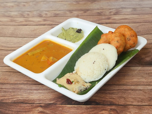 Medu vada와 Idli 또는 idly의 남부 인도식 아침 식사 조합은 전통적이고 인기 있는 음식으로 처트니와 삼바 그릇을 반찬으로 제공합니다.