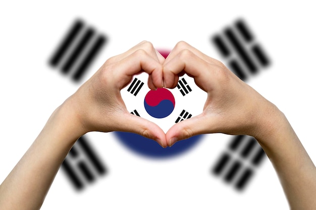 Foto bandiera della corea del sud con due mani a forma di cuore segno d'amore che esprime amore o affetto