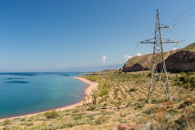 The southern shore of the Issyk Kul lake Kyrgyzstan Electricity pylon