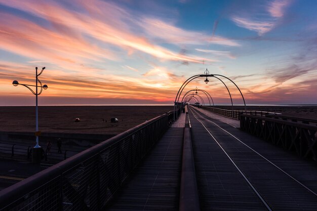 Foto southport pier over het strand tegen de hemel bij zonsondergang