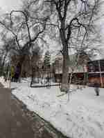 Photo soviet brutalist structure behind snowcovered trees with no leaves in winter