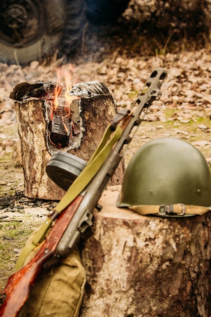 Soviet helmet and pistol machine gun near the fire