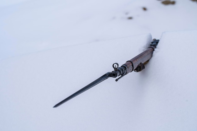 Soviet Mosin rifle with a bayonet in a snowy trench in winter