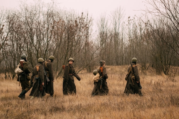 Soviet soldiers during the Second World War on the field with dry grass. Autumn, Gomel, Belarus