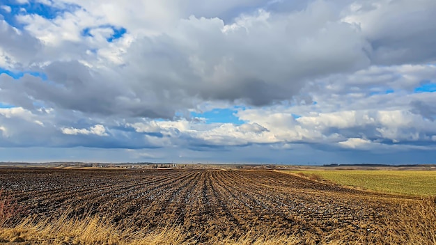 Sowing time in Ukraine during the war Preparing fields for sowing grain Blue sky plowed land terror