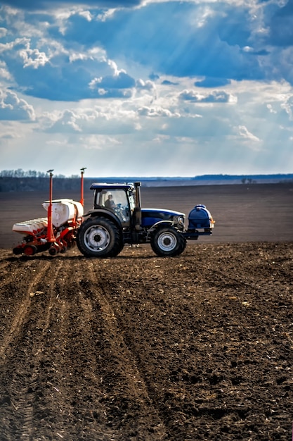 Sowing work in the field. Tractor with seeder.