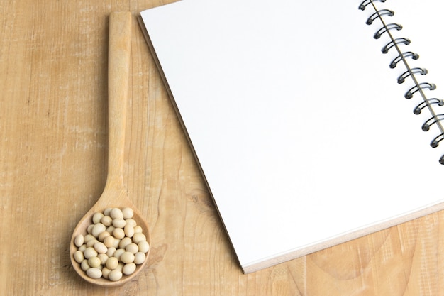 Soy bean on spoon and white blank book