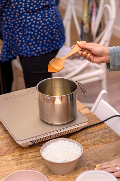 Soy candle creation workshop Melting wax A woman39s hand with a wooden spoon