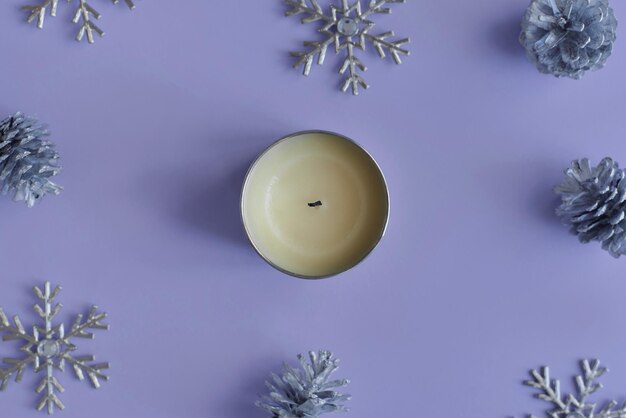 Soy candle in a metal jar on purple background Winter and christmas season top view