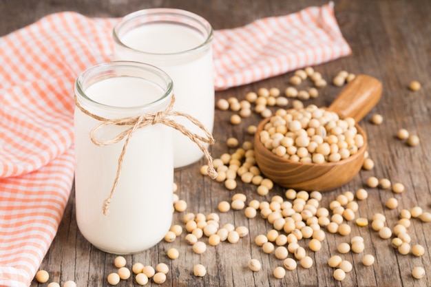 Soy milk in a glass jar on an old wood background.