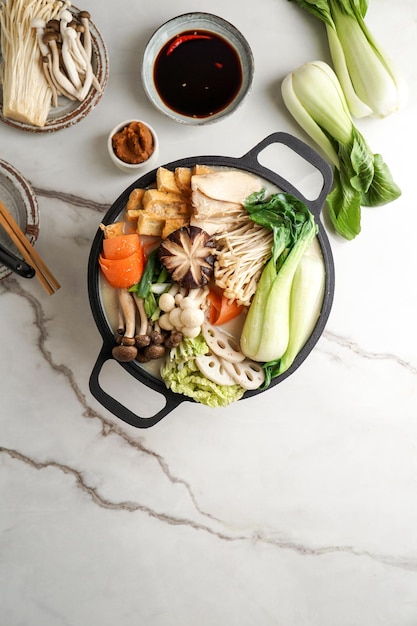 Photo soy milk hot pot recipe with napa cabbage mushrooms and thinly sliced pork cooked in a creamy and savory soy milk broth