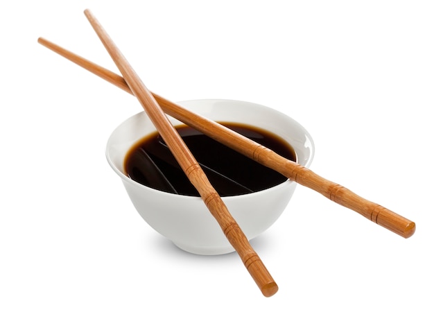 Soy sauce and chopsticks on white