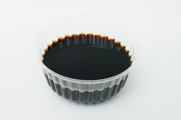 Soy sauce in a disposable crockery on a white background