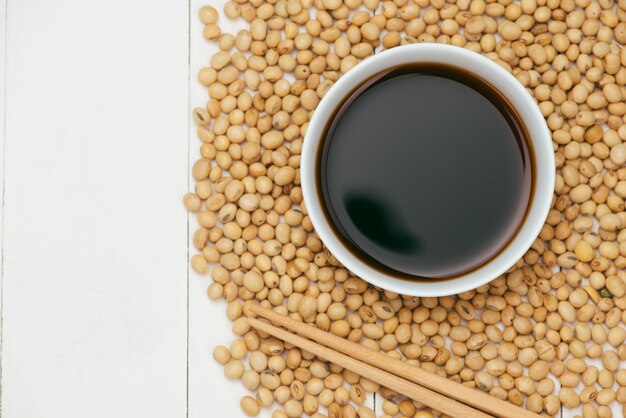 Photo soy sauce and soy bean on wooden table