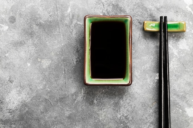 Soy sauce in traditional Asian ware on a gray background. Top view, copy space. Food background