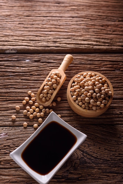 Soy Sauce with soy bean on wooden background.