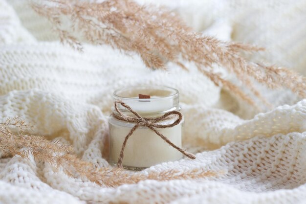 Soy wax candle in transparent glass with dried flowers