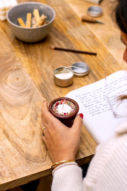 Soy wax candle workshopElderly woman picks up her handmade candle from the wooden table