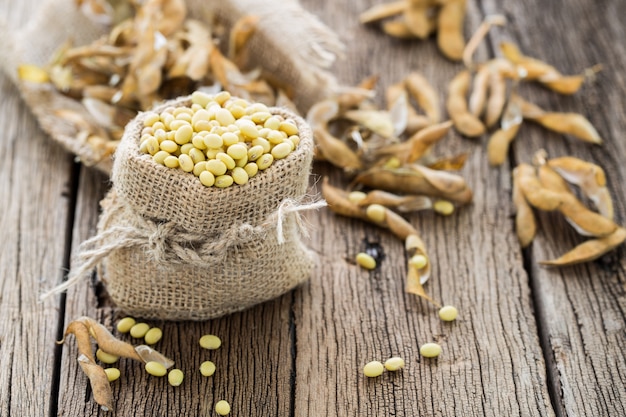 Soya beans in a sack on a old wooden table