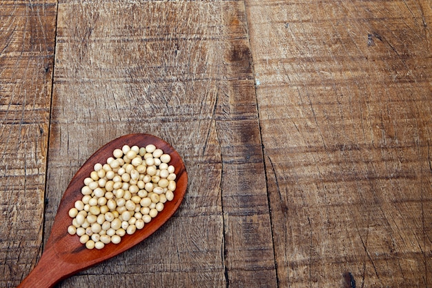 Soya beans on wooden spoon with area for text