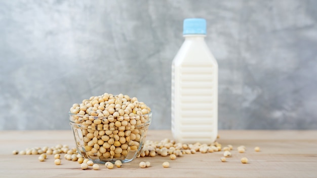 Soybean in a bowl and soy milk on a wooden background.