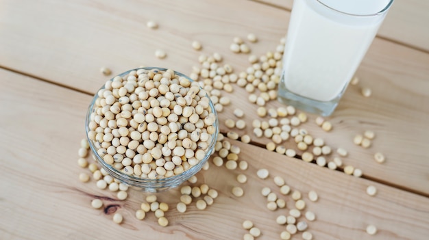 Soybean in a bowl and soy milk on a wooden background.