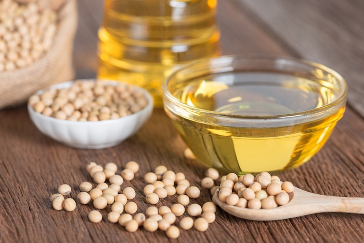 Photo soybean oil and soybean on wooden table.