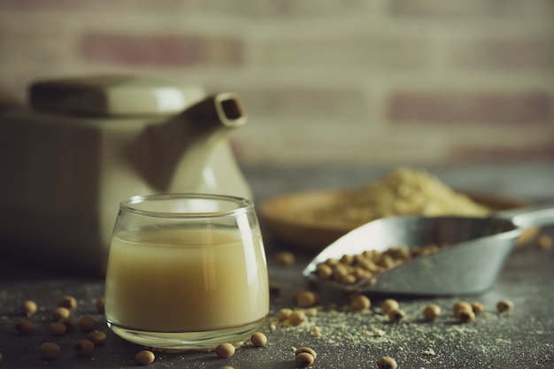 Il latte di soia nel bicchiere e il bollitore sono posti accanto