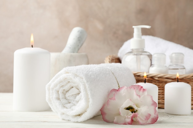 Spa accessories and flower on white wood, close up