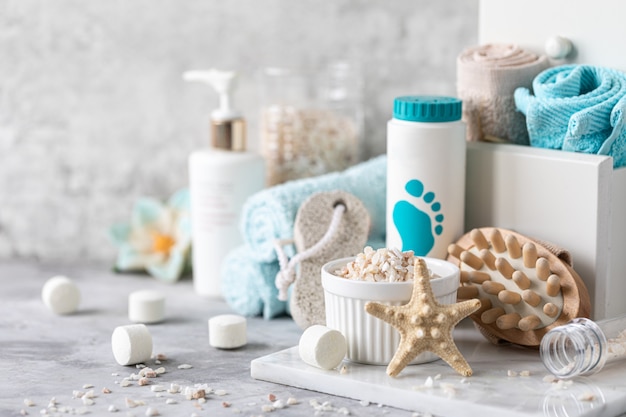 Spa accessories - sea salt, powder, tablets for a bath, pumice, cream on a light background. Healthy lifestyle concept. Cosmetics for skin care feet. Decor for the bathroom.