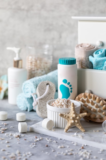 Spa accessories - sea salt, powder, tablets for a bath, pumice, cream on a light background. Healthy lifestyle concept. Cosmetics for skin care feet. Decor for the bathroom.