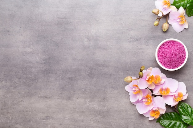 Фото Спа ароматерапия фон, плоская планировка различных косметических средств, украшенных простыми цветами орхидеи.