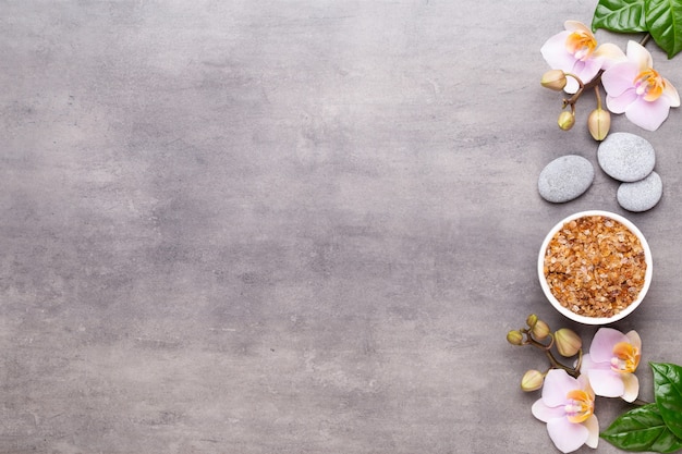 Spa aromatherapy background, flat lay of various beauty care products decorated with simple orchid flowers.