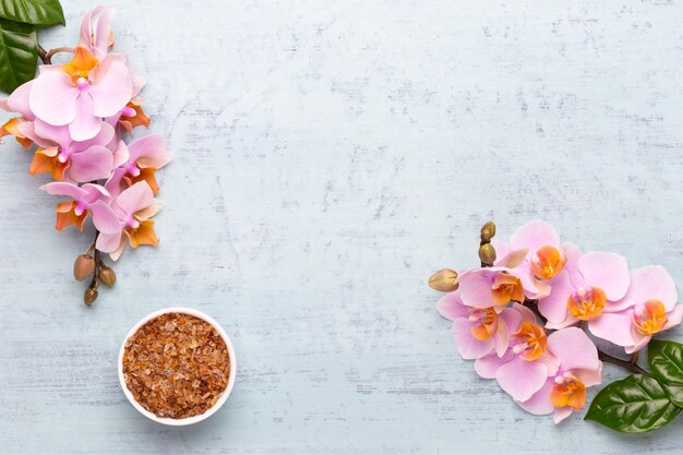 Spa aromatherapy background, flat lay of various beauty care products decorated with simple orchid flowers.