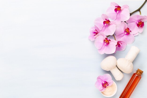 Spa aromatherapy, flat lay of various beauty care products decorated with simple orchid flowers.